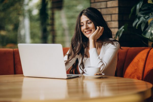 Young beautiful business woman working on cimputer in a cafe